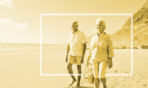 retired couple walking on a beach
