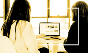 two coworkers looking at the same computer